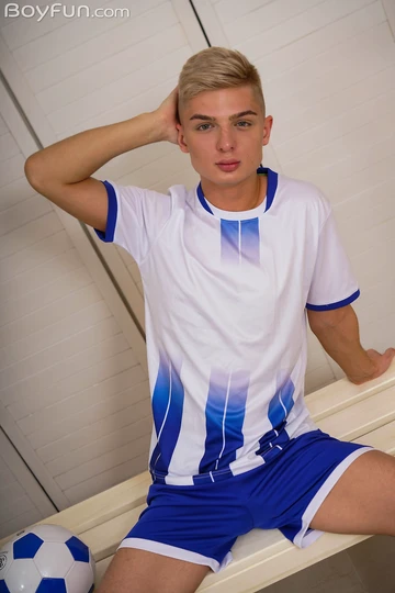 Cute football boy getting naked